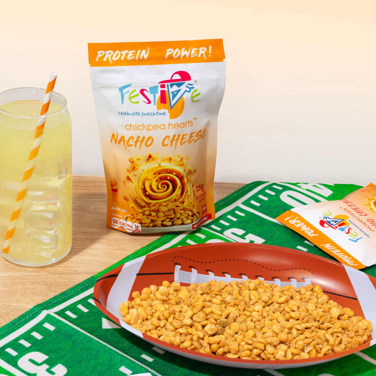 Festive nacho cheese snack with a drink on a table with a sports-themed mat.