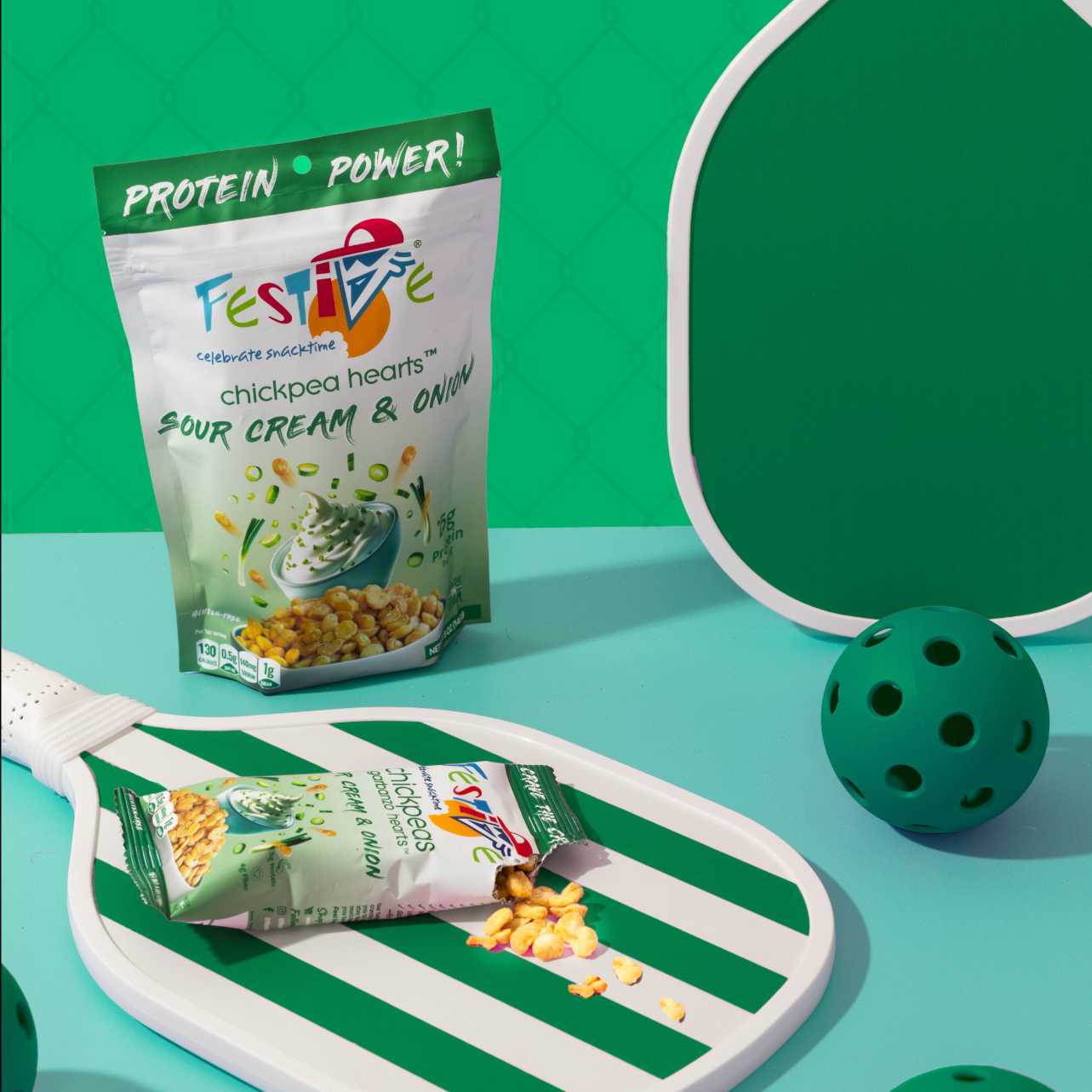 Festive Chickpeas package on a green and white striped tray with a bowl of chickpeas and green balls on a teal background.