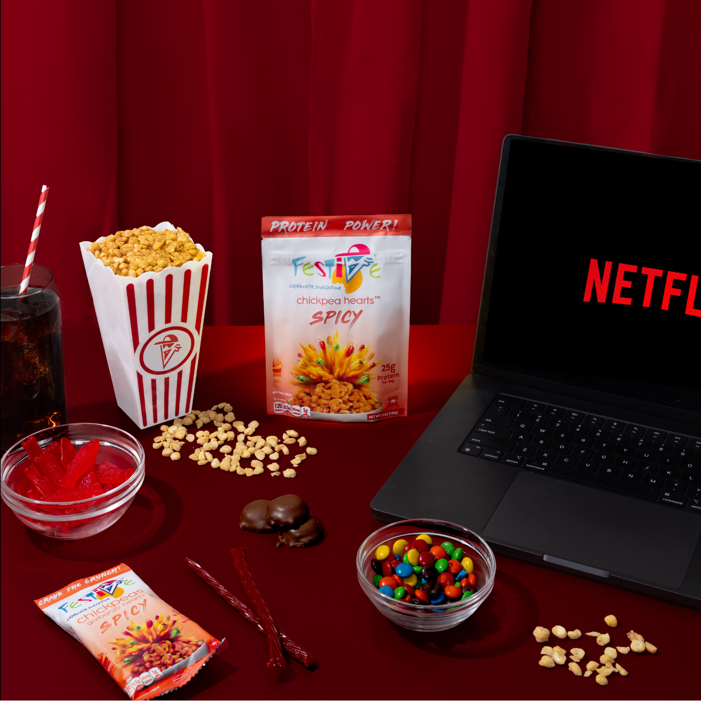 Snacks and a laptop with Netflix open on a red surface